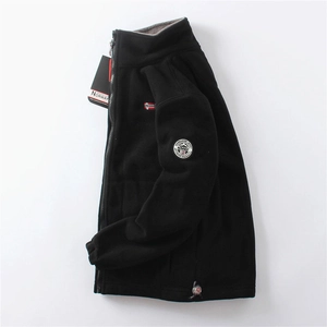 Close-up of black fleece jacket showing stand collar, zipper, and Norway flag sleeve patch