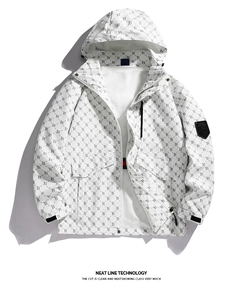 Detailed view of white hooded jacket featuring all-over monogram print and sleeve badge