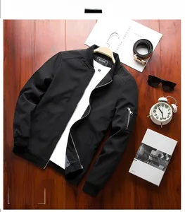Flat lay of men's black bomber jacket with sleeve zip pocket on vintage wood background