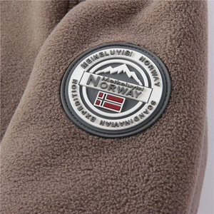 Detail of the outdoor mountain patch on a warm brown fleece jacket sleeve