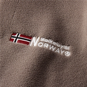 Detailed embroidery of Meikeluyisi and Norway on soft brown fleece fabric texture