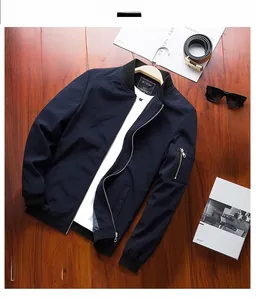 Detail of dark blue bomber jacket sleeve featuring a utility zipper pocket and ribbed cuff