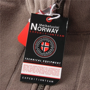 Detail of high-density brown polar fleece fabric with Geographical Norway brand tag
