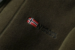 Detailed embroidery of Norway flag and logo on green fleece jacket fabric