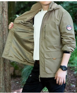Detail einer khakifarbenen Outdoorjacke mit Netzfutter und praktischen Sporttaschen