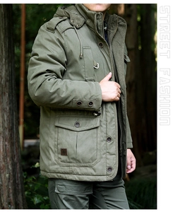 Detail of military green hooded parka showing large flap pockets and shoulder epaulettes