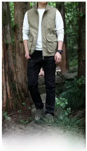 Men's khaki multi-pocket outdoor vest styled with hoodie and cargo pants in nature