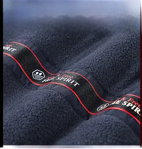 Detailed macro view of soft navy blue fleece fabric with embroidered FREE SPIRIT text ribbon