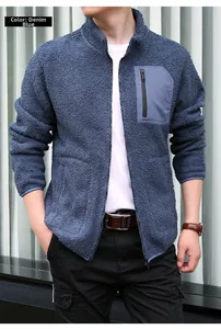 Close-up of denim blue polar fleece jacket showing contrast chest pocket and zipper detail