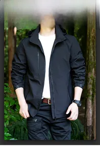 Detail of waterproof black hooded jacket featuring zipper pockets and adjustable velcro cuffs
