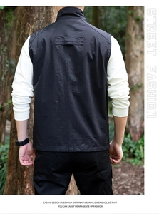 Back view of men's outdoor utility vest with rear strap detail in a forest setting