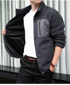 Detail view of smooth inner lining and zipper pocket on dark gray fleece jacket