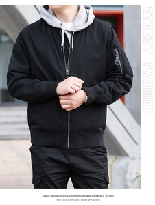 Détail d'une veste utilitaire noire avec capuche double couche et poche de manche
