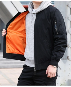 Détail du blouson bomber noir avec doublure orange vif et poche sur la manche gauche