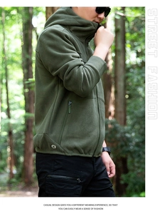 Detail shot of men's olive green fleece hooded jacket with side zipper pockets in forest