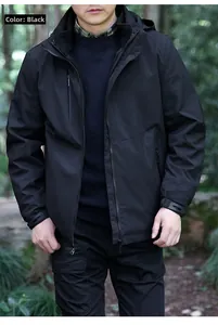 Détail des poches zippées étanches et poignets Velcro sur une veste d'extérieur noire pour hommes