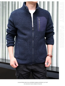 Detail of dark blue fleece jacket showing stand collar and contrast nylon chest pocket