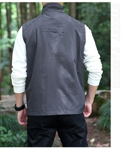 Back view of a dark grey multi-pocket outdoor vest with fine texture and stand collar