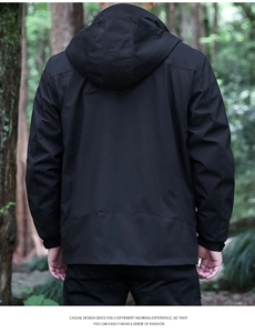 Vue arrière d'un coupe-vent à capuche noir pour homme dans un décor de forêt