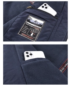 Detail view of the deep blue fleece jacket featuring a large zippered chest pocket and lining