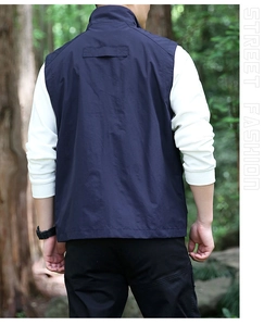 Rear view of men's dark blue outdoor vest with stand collar in forest setting