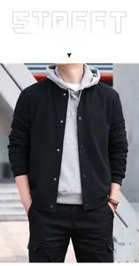 Detail of waffle-textured black varsity jacket with silver snap buttons and layered hoodie