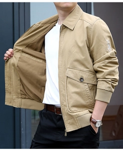 Detail of khaki men's cotton bomber jacket showing eagle embroidery and utility pockets