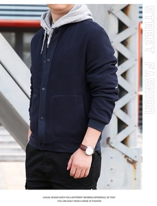 Detail of waffle-textured dark blue men's jacket with gray drawstring hoodie and button closure