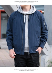 Gros plan sur un blouson cargo bleu marine avec capuche grise et poche fonctionnelle au bras