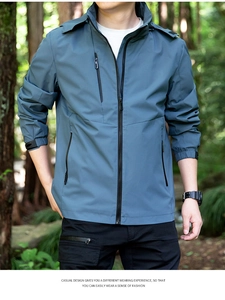 Outdoor male model wearing a blue-grey waterproof hooded jacket with functional zip pockets