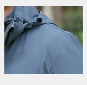 Gros plan des coutures haute densité sur l'épaule d'une veste à capuche outdoor pour hommes