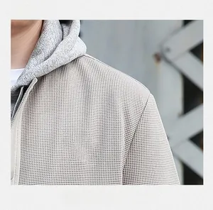 Detail view of the waffle texture fabric and shoulder design on a beige men's jacket
