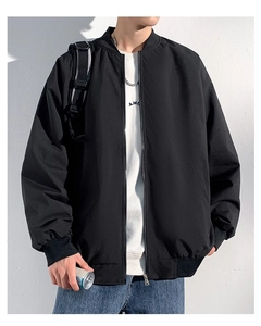 Detail of ribbed cuffs and hem on men's black winter bomber jacket with zipper closure