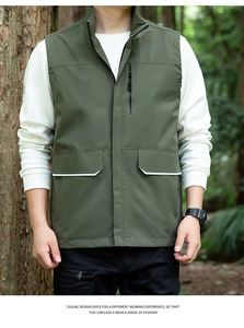 Detail of army green outdoor vest showing stand collar and pockets with reflective strips