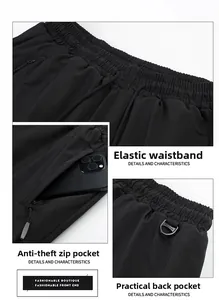 Detail view of elastic drawstring waist and secure zipper pockets on black joggers