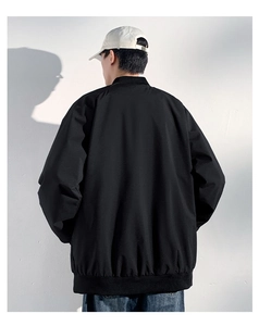 Back view of a man wearing a black padded bomber jacket with ribbed cuffs and hem