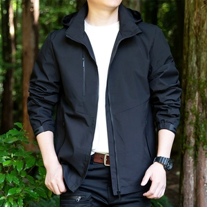Men's black waterproof hooded casual jacket for autumn in a natural outdoor woodland setting