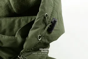 Detail view of the adjustable elastic drawstring and metal eyelet on army green winter jacket