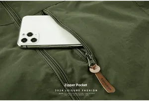Detail of army green outdoor jacket featuring deep zipper pocket and leather puller