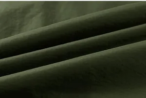 Detailed macro view of dark green waterproof warm cotton fabric with fine texture