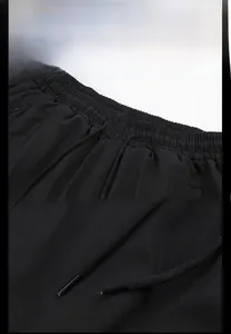 Detail of black sports trousers featuring an elastic waistband and adjustable drawstring