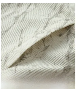 Detail einer Cordjacke-Seitentasche mit grauem Marmordruck auf cremefarbenem Stoff