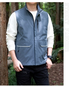 Detail of grey-blue outdoor vest featuring a stand collar and reflective pocket strips