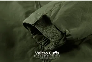 Detail of adjustable velcro cuff on a dark green waterproof outdoor tactical jacket