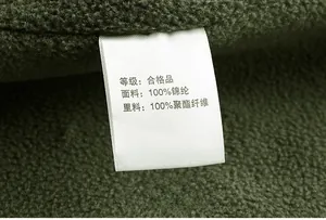Detailed macro view of the inner care label on a green fleece-lined waterproof jacket