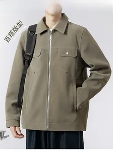 Detail of olive green jacket featuring contrast white stitching and buttoned chest pockets