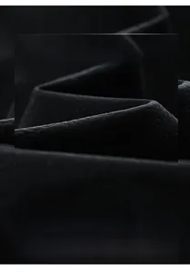 Close-up detail of high-quality black textured woven fabric for men's casual jacket
