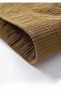 Close-up of corduroy jacket hem showing precise stitching and ribbed fabric texture