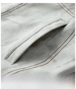 Detailed macro view of suede jacket pocket with reinforced brown double stitching