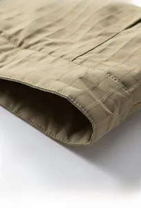 Macro shot of the hem detail on a khaki waffle knit jacket with precise stitching finish